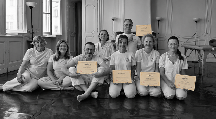 Une promotion de l'Académie MTJ AURA, en tenue de pratique blanche, réunie autour de leurs certificats