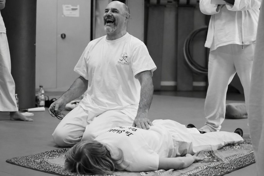 Un praticien de l'Académie MTJ AURA donnant une séance de Shiatsu à une élève allongée, en tenue blanche